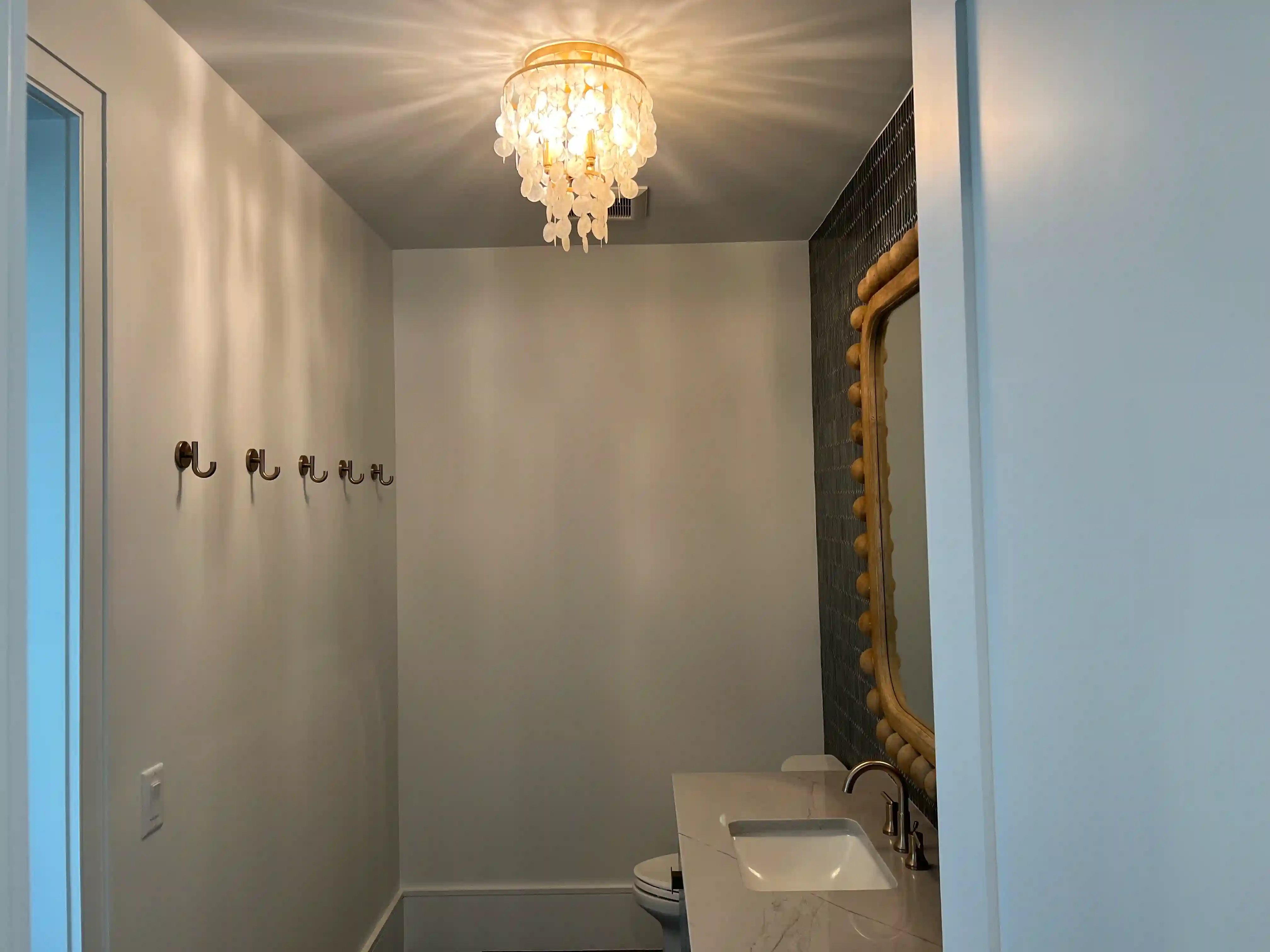 A powder room with a shell chandelier, finished by the PG Quality Solutions team