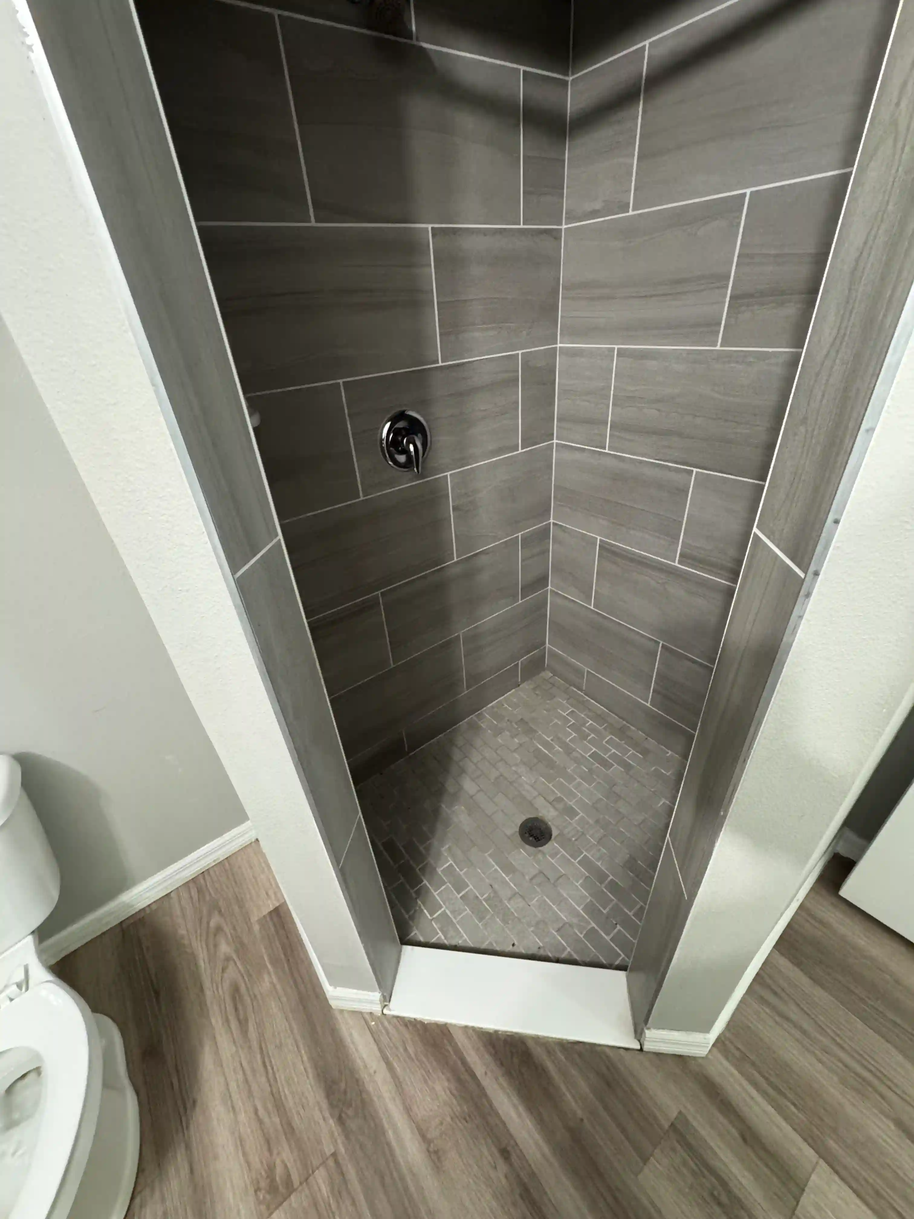Shower gray tile stall vacant unit